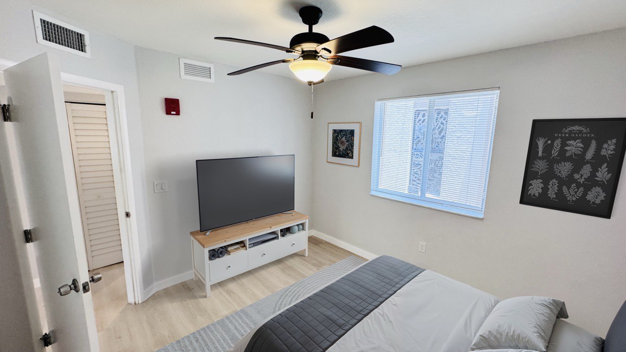 Bedroom with ceiling fan and TV